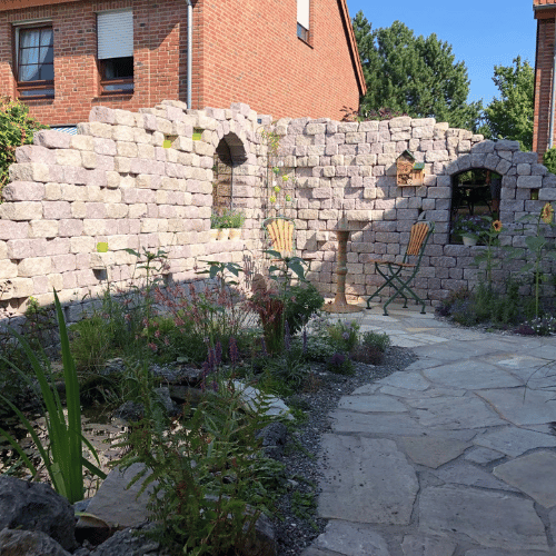 Natursteinmauer im Garten mit Sitzbereich und mediterraner Gestaltung