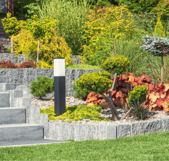 Moderne Gartengestaltung mit Natursteinmauer, Bepflanzung und Gartenbeleuchtung in Paderborn