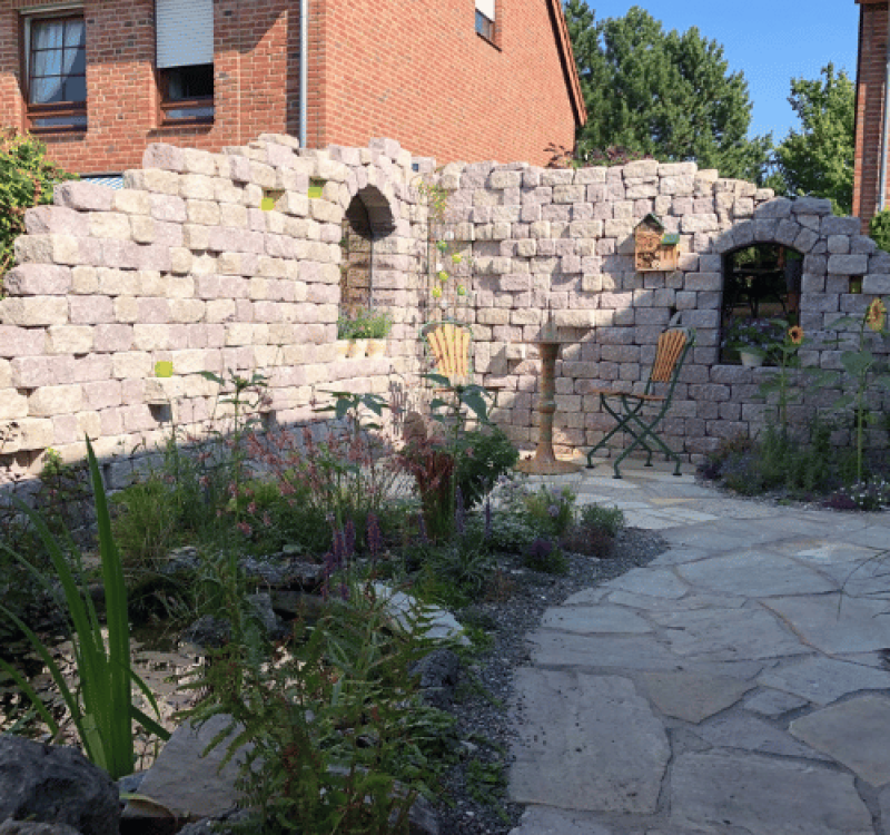 Natursteinmauer im Garten mit Sitzbereich und mediterraner Gestaltung